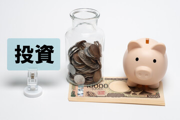 お金と豚の貯金箱と硬貨と投資のタイトル