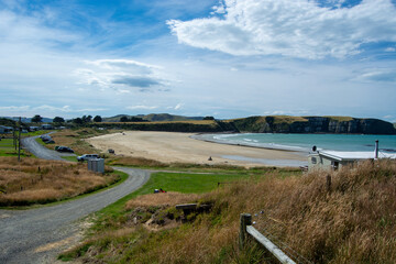 Scenic Beach View with Gentle Waves and Grassy Hills