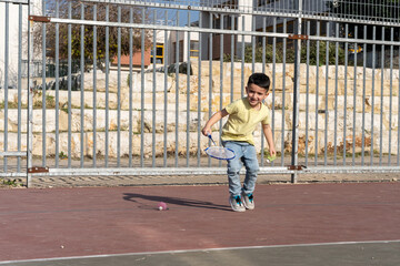 Energetic Young Boy With A Badminton Racket And Shuttlecock In Hand, Training In A Sunlit Schoolyard, Focused And Ready To Play.