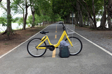 Bicycle and bag on road in the garden at city park