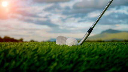 Golf clubs and balls on a green lawn in a beautiful golf course with morning sunshine.