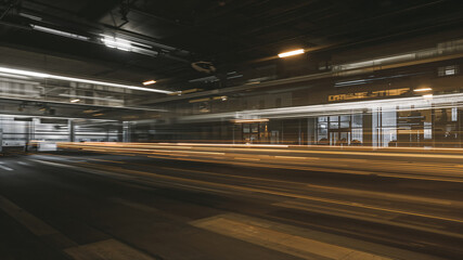 Light trails illuminating urban night street under bridge