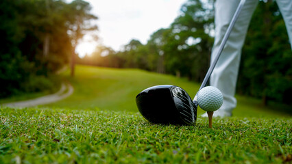 Golfer putting ball on the green golf, lens flare on sun set evening time.