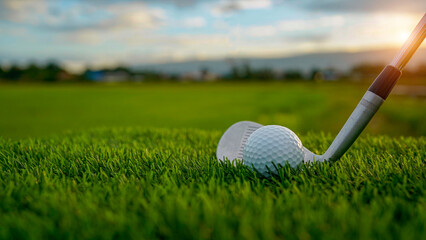 Golf clubs and balls on a green lawn in a beautiful golf course with morning sunshine.