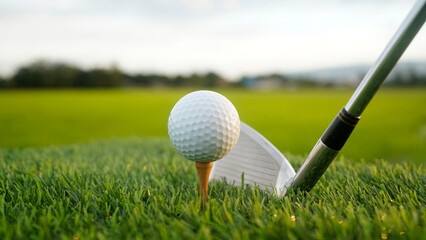 Golf clubs and balls on a green lawn in a beautiful golf course with morning sunshine.