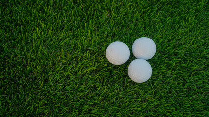 Golf balls on a green lawn in a beautiful golf course with morning sunshine.