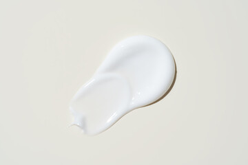 Luxurious cream dabbed and blended on neutral surface, highlighting smooth application for...