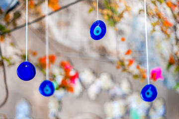 Glass evil eye amulets hanging outdoors, providing protection against negative energy, according to...