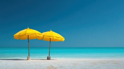 Bright yellow beach umbrellas standing on a pristine shore under a clear sky with turquoise water in the background