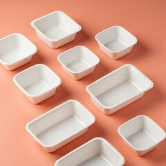 A collection of empty, white, square and rectangular food containers arranged on a coral background.
