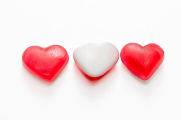 Fruit jelly beans in many colors in a glass bowl on a white background.