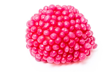 Fruit jelly beans in many colors in a glass bowl on a white background.