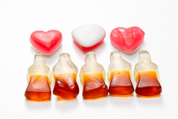 Fruit jelly beans in many colors in a glass bowl on a white background.