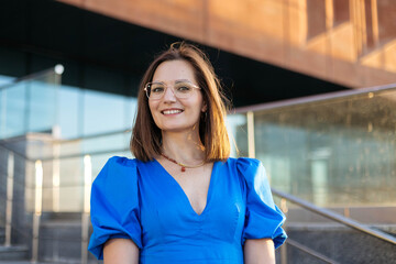 Portrait of a charming young woman at sunset in a modern city.