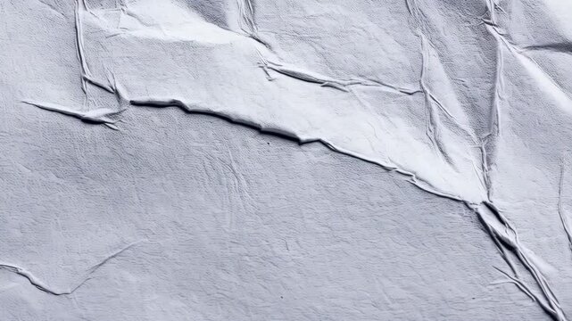 Abstract gray texture of crumpled paper with irregular surface folds creating a three-dimensional surface, background for design.