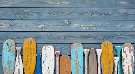 Weathered wooden paddles on rustic blue plank background       © Lifeisbeautiful
