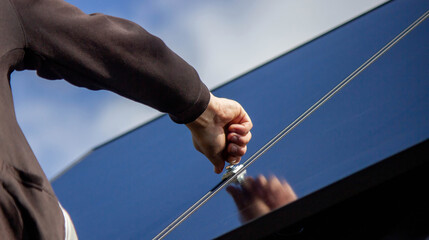 A man is installing solar panels on a roof. Selective focus