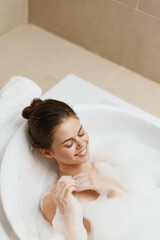 Happy woman relaxing in a bubble bath, enjoying self-care, surrounded by calming ambiance and soft...