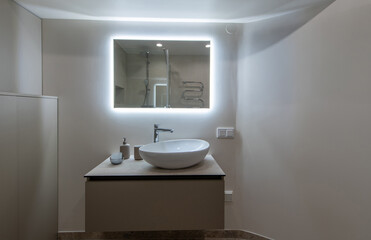 Modern Restroom Interior With Illuminated Vanity Mirror and Minimalist Decor