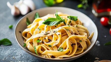Close-up of a bowl of delicious pasta with basil, pepper, and garlic.
