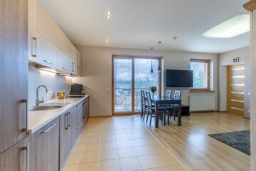 Modern Home Open Plan Kitchen and Dining Room with Wooden Furniture and Natural Light