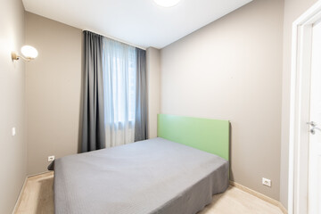 Minimalist Bedroom with Neutral Tones and Green Accented Headboard