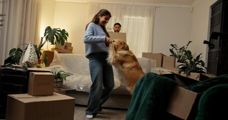 Dancing, box and couple with dog in new home, rental apartment and property for homeownership. Real estate, music and happy man, woman and pet celebrate for relocation, mortgage and house investment - Powered by Adobe