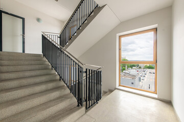 Modern Staircase Interior with Large Window Overlooking Urban Street View