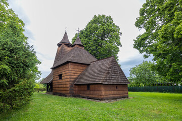 Traditional wooden church nestled in a serene, green landscape