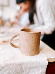 Pottery workshop displays freshly crafted clay mug on worktable in a creative space