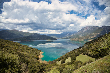 A beautiful, green lake sitting tranquil in the mountains of Greece 