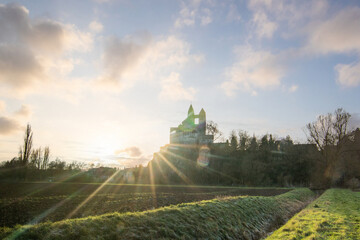 A winter landscape shot at sunrise. Plenty of nature and a large church on a rock. The former collegiate church of St. Lubentius Limburger, Dietkirchen, Hesse