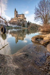 A winter landscape shot at sunrise. Plenty of nature and a large church on a rock. The former collegiate church of St. Lubentius Limburger, Dietkirchen, Hesse