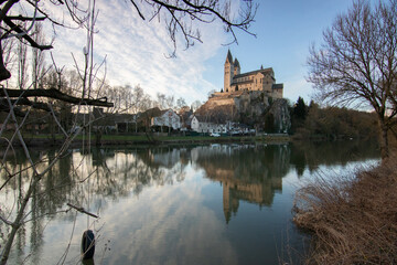 A winter landscape shot at sunrise. Plenty of nature and a large church on a rock. The former collegiate church of St. Lubentius Limburger, Dietkirchen, Hesse