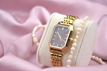Closeup minimal fashion wristwatch for women on pink background.