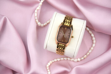 Closeup minimal fashion wristwatch for women on pink background.