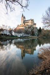 A winter landscape shot at sunrise. Plenty of nature and a large church on a rock. The former collegiate church of St. Lubentius Limburger, Dietkirchen, Hesse