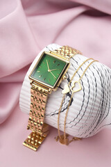 Closeup minimal fashion wristwatch for women on pink background.
