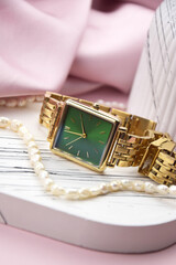 Closeup minimal fashion wristwatch for women on pink background.