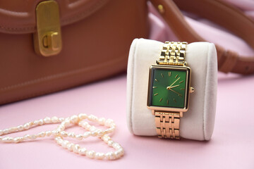 Closeup minimal fashion wristwatch for women on pink background.