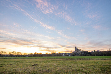 A winter landscape shot at sunrise. Plenty of nature and a large church on a rock. The former collegiate church of St. Lubentius Limburger, Dietkirchen, Hesse