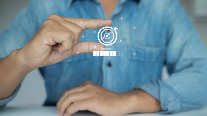 Businessman holding virtual target icon with loading progress bar, representing business goal...