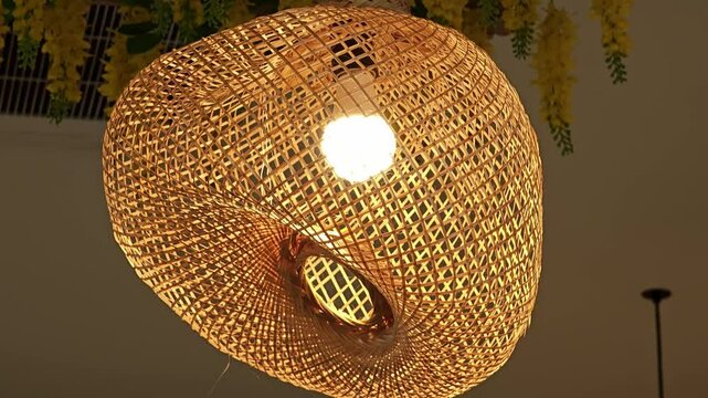 Hanging woven bamboo lamp with warm glowing lights.
