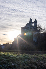A winter landscape shot at sunrise. Plenty of nature and a large church on a rock. The former collegiate church of St. Lubentius Limburger, Dietkirchen, Hesse