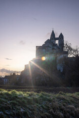 A winter landscape shot at sunrise. Plenty of nature and a large church on a rock. The former collegiate church of St. Lubentius Limburger, Dietkirchen, Hesse