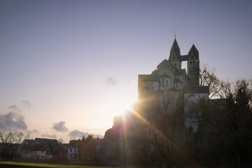 A winter landscape shot at sunrise. Plenty of nature and a large church on a rock. The former collegiate church of St. Lubentius Limburger, Dietkirchen, Hesse