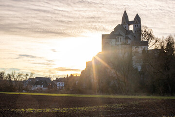 A winter landscape shot at sunrise. Plenty of nature and a large church on a rock. The former collegiate church of St. Lubentius Limburger, Dietkirchen, Hesse