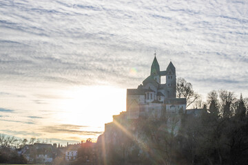 A winter landscape shot at sunrise. Plenty of nature and a large church on a rock. The former collegiate church of St. Lubentius Limburger, Dietkirchen, Hesse
