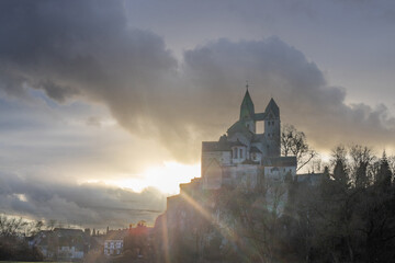 A winter landscape shot at sunrise. Plenty of nature and a large church on a rock. The former collegiate church of St. Lubentius Limburger, Dietkirchen, Hesse
