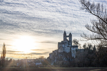 A winter landscape shot at sunrise. Plenty of nature and a large church on a rock. The former collegiate church of St. Lubentius Limburger, Dietkirchen, Hesse